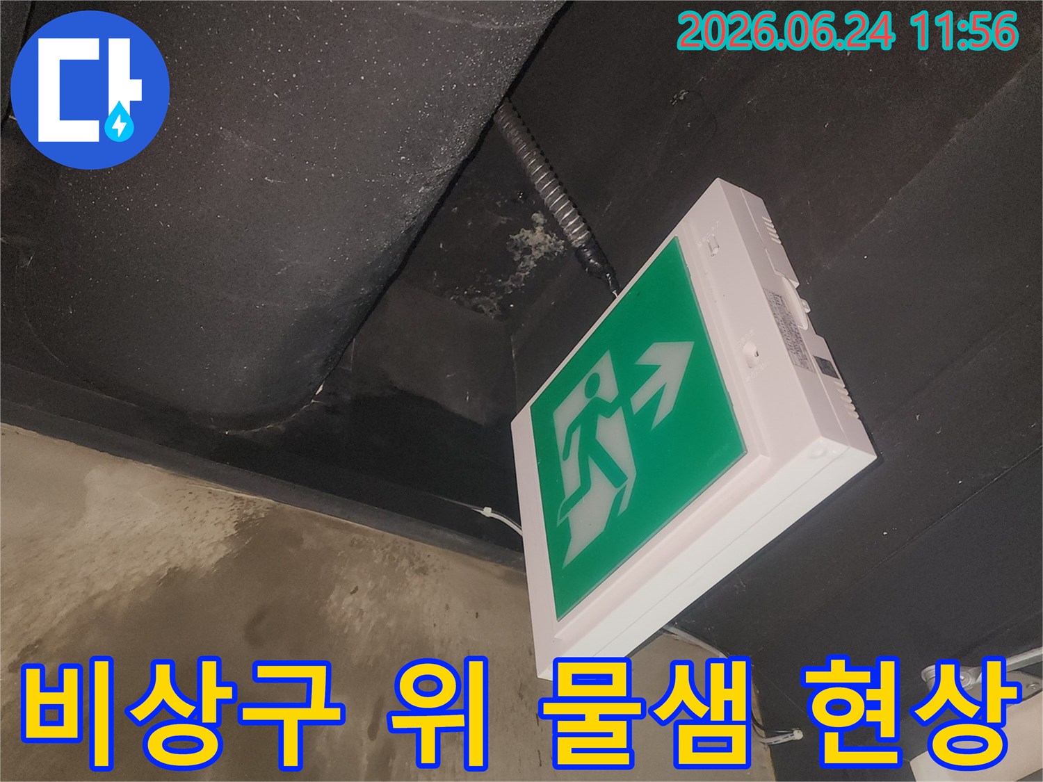 천장 마감재 손상과 함께 나타난-비상구 아래 누수 상황을 기록한 것입니다