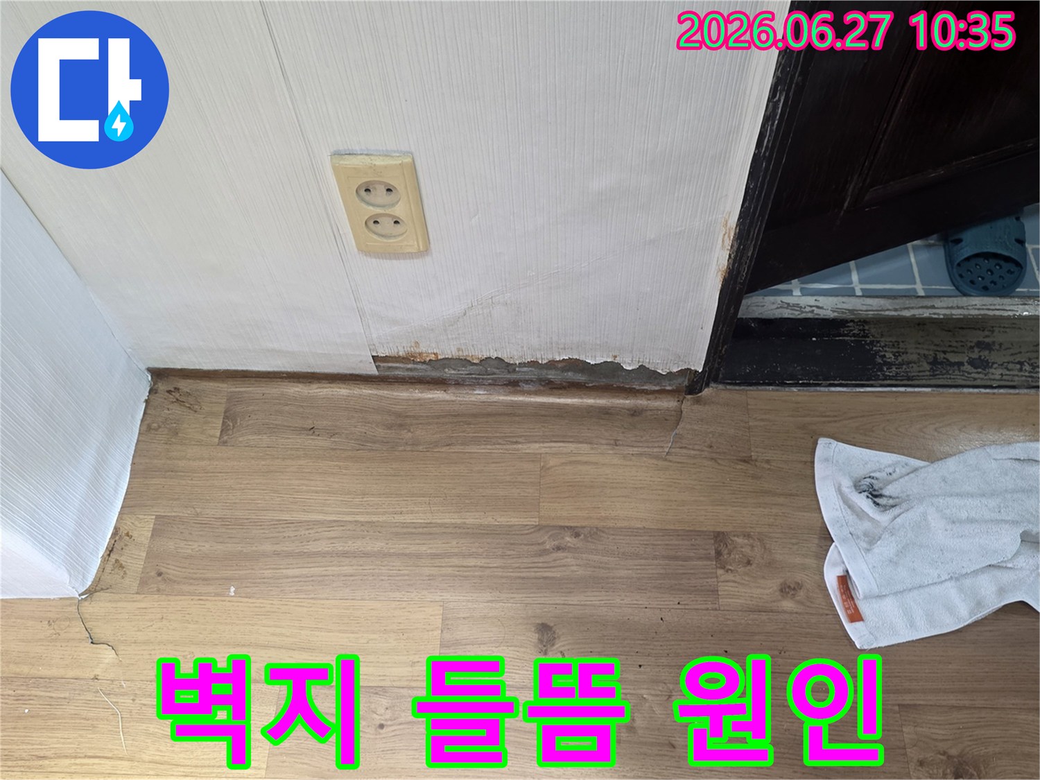 벽지 하단이 물에 젖어 들뜨고-벽면이 손상된 누수 현장의 모습입니다.