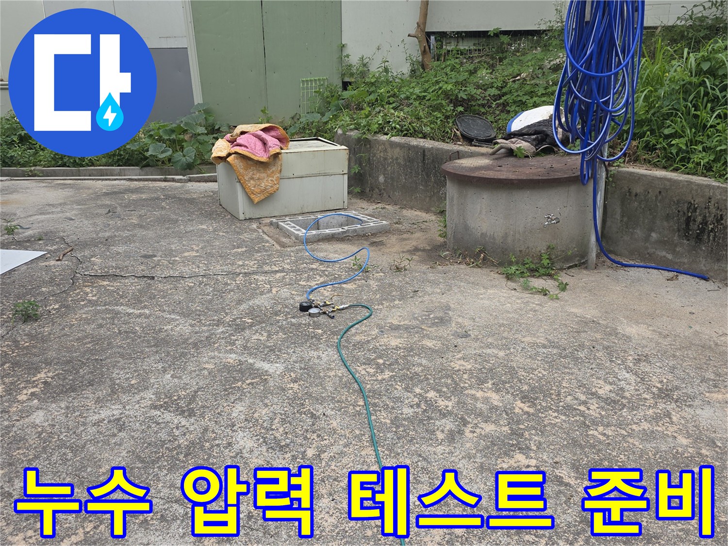 누수 탐지 전문 엔지니어가-옥외 배관의 압력을 점검하기 위해-장비를 연결하는 모습입니다