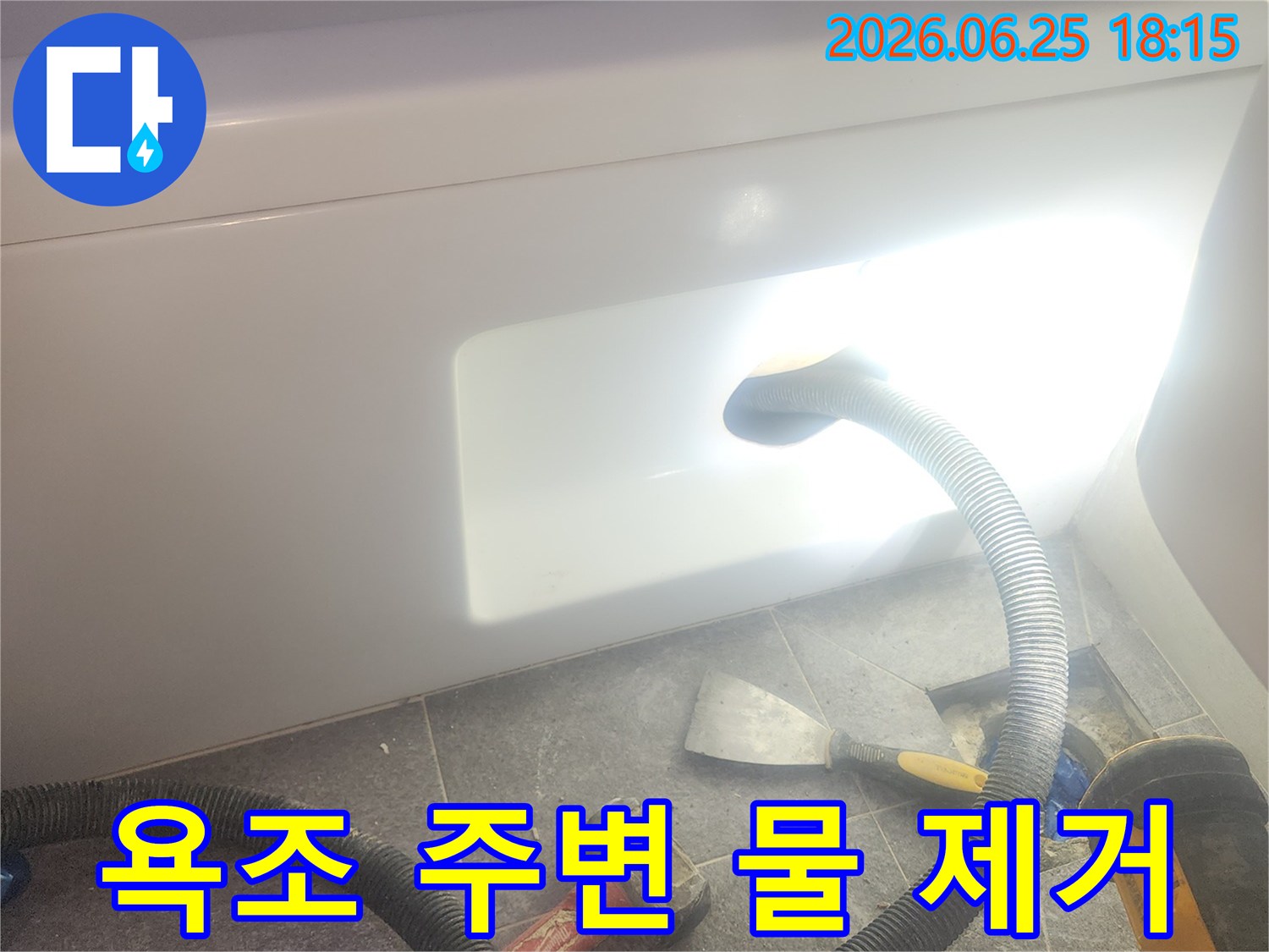 욕조 주변에-고인 물을-전문 석션 장비로-흡입하여-제거하는-누수 작업 현장입니다.