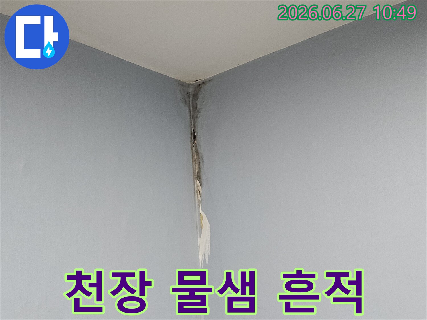 천장과 벽이 만나는 모서리 부분에 물이 새어 나와 벽지가 들뜨고 변색된 모습으로-누수 피해가 진행 중임을 명확하게 보여주는 사진입니다.