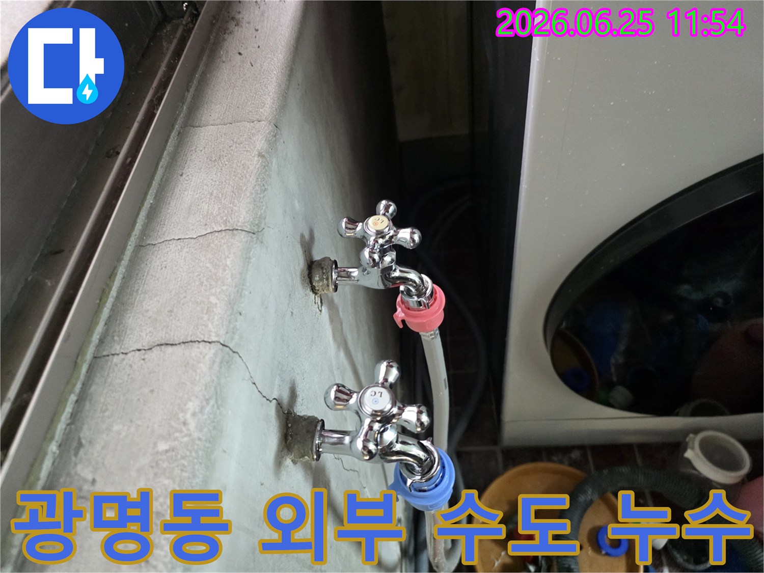 광명동 주택의 외부 벽면에 설치된 수도꼭지에서-물이 새는 현상과 함께 벽면이 젖어 있는 모습입니다.