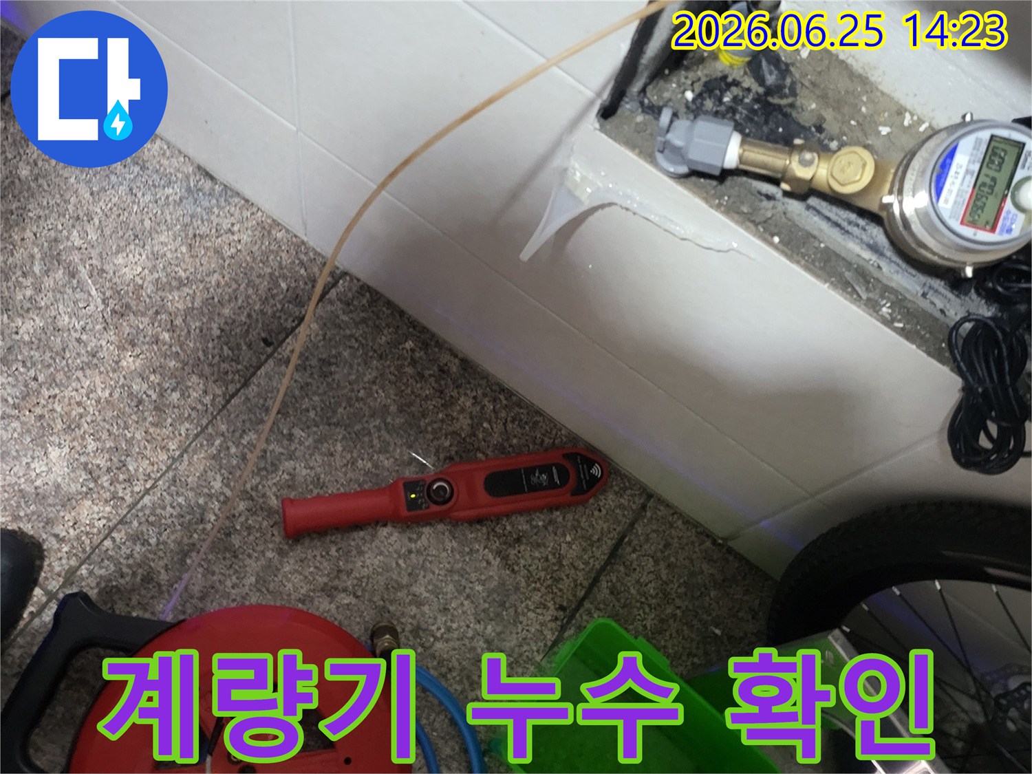 수도 계량기 주변에서-누수 여부를 확인하기 위한-장비 연결 작업이-진행 중입니다.