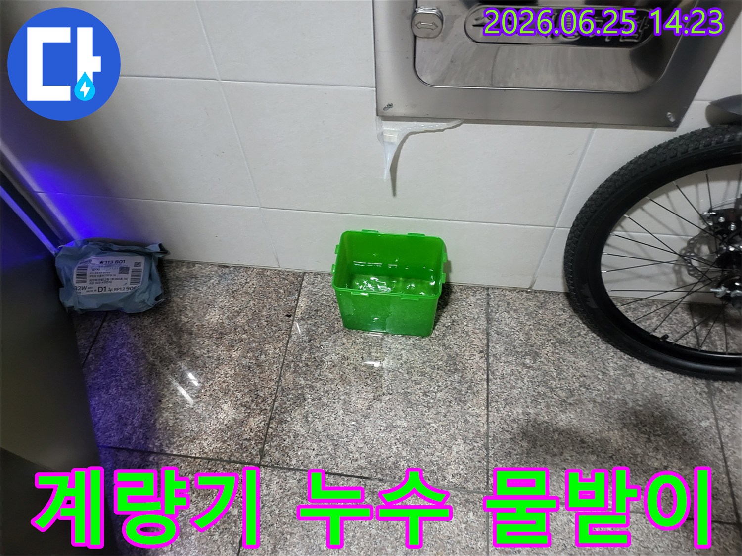 수도계량기함-아래에서-물이-새어-나와-초록색-물받이에-고이는-상황을-보여주는-누수-현장-사진