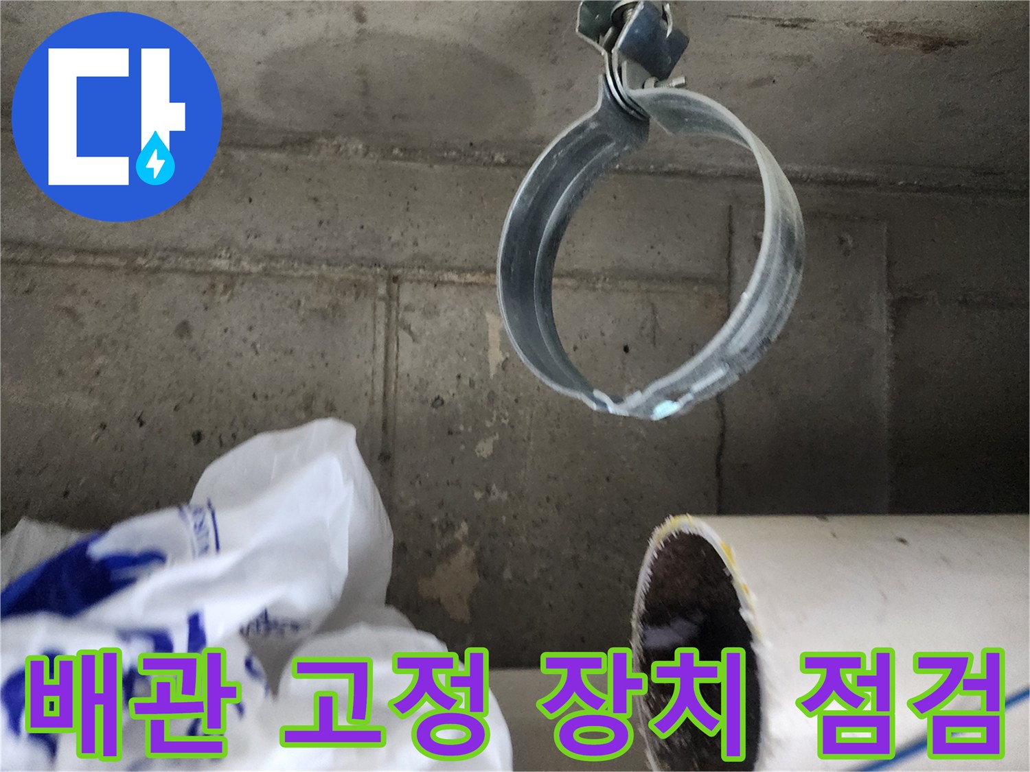 금속 클램프로 고정된 배관의 연결 부위 상세 사진입니다.