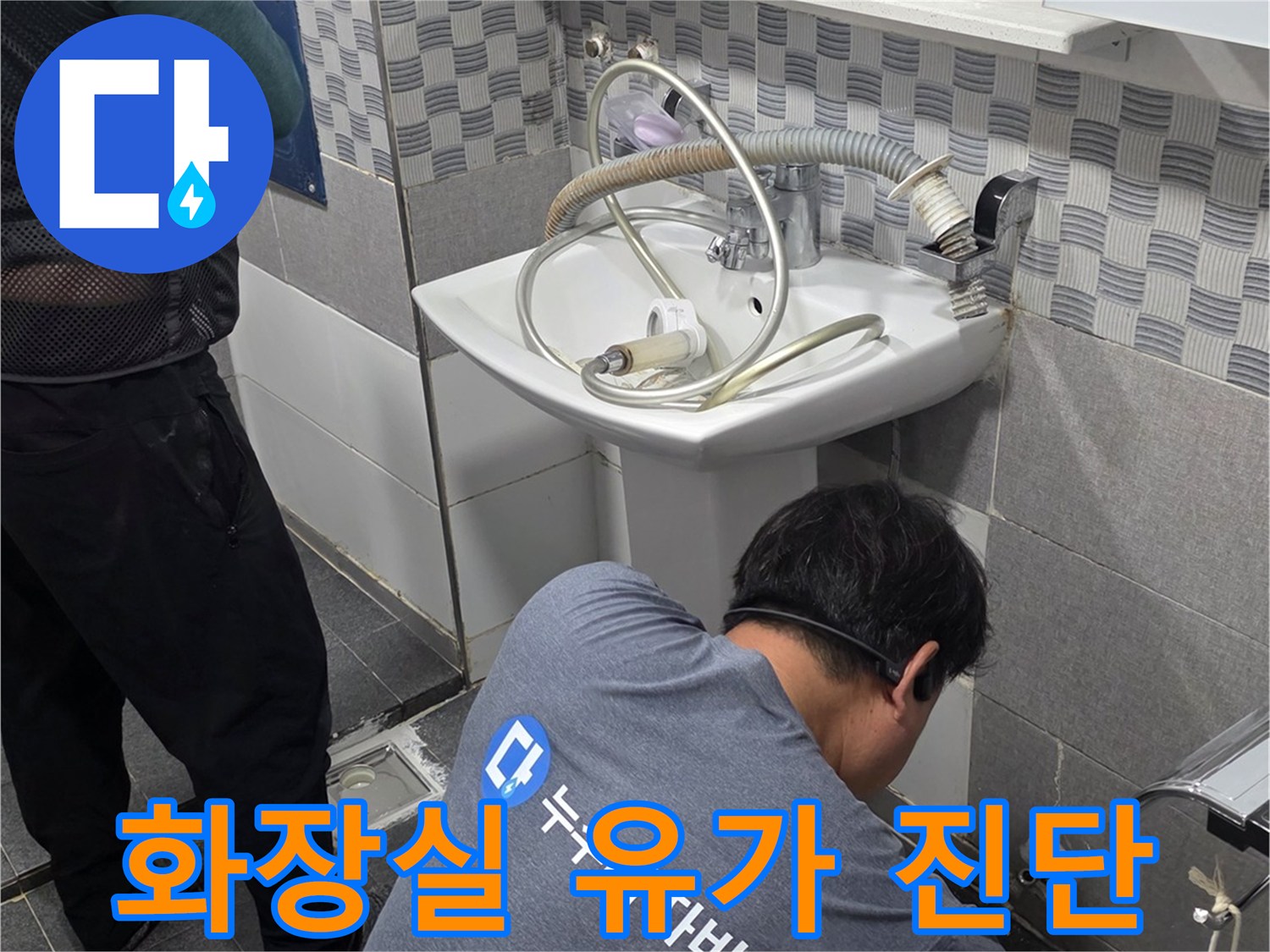 욕실 바닥 배수구 주변의 누수 지점을 찾기 위해 엔지니어가 자세히 들여다보고 있습니다.
