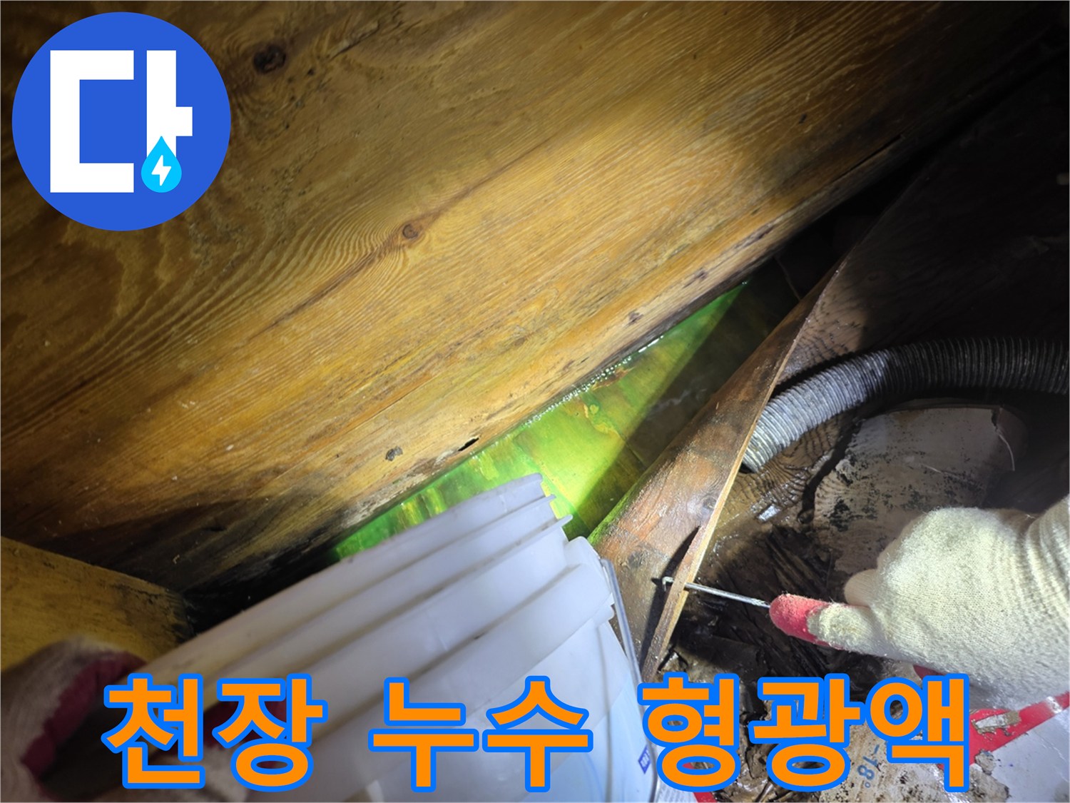 어두운 천장 내부에서 형광물질로 누수 원인을 파악하는 전문 기술자의 작업 현장