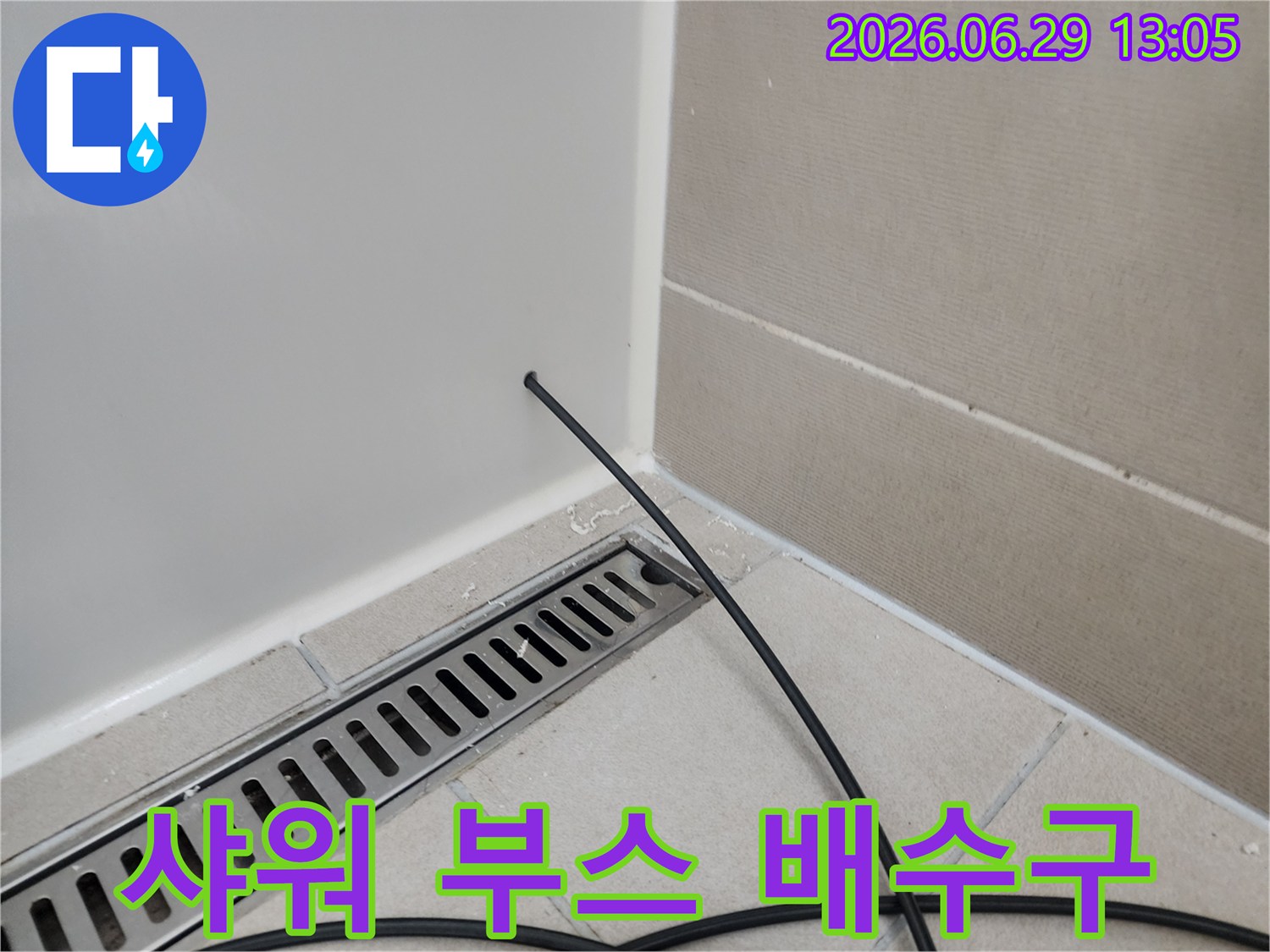 샤워-부스-내부-배수구-주변에서-발생한-누수를-탐지하는-전문-기술자의-작업-현장