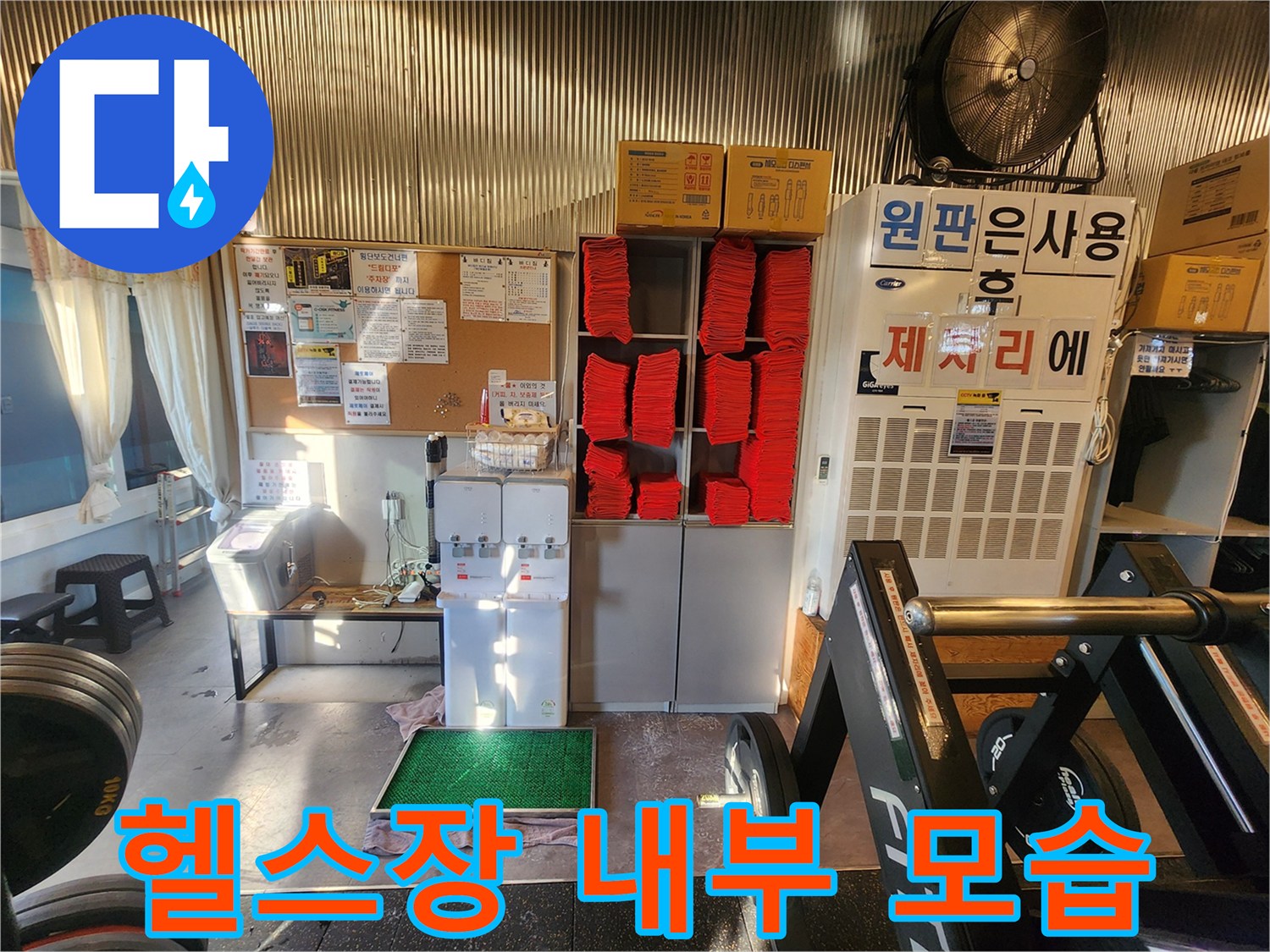 수건 보관함과 운동 기구가 배치된 헬스장 실내