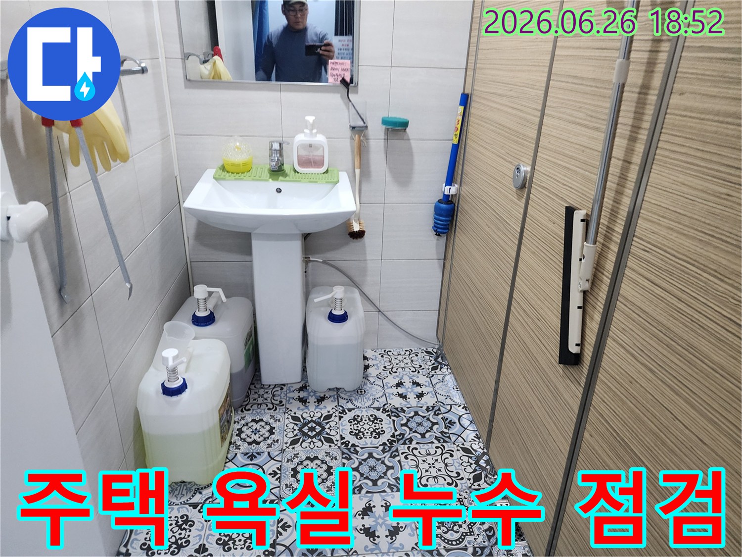 이 이미지는 연천 주택 욕실에서 누수 엔지니어가 세면대와 바닥 타일 주변을 점검하는 모습을 담고 있습니다-노후 배관으로 인한 누수 가능성을 염두에 두고 정밀 검사가 진행됩니다.
