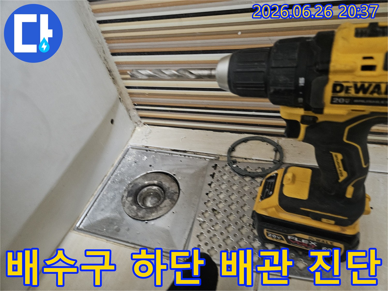 서울 중랑구에서 배수구 하단 배관 문제를-진단하기 위해 드릴로 바닥을 타공하는-작업 현장을 담은 이미지입니다.