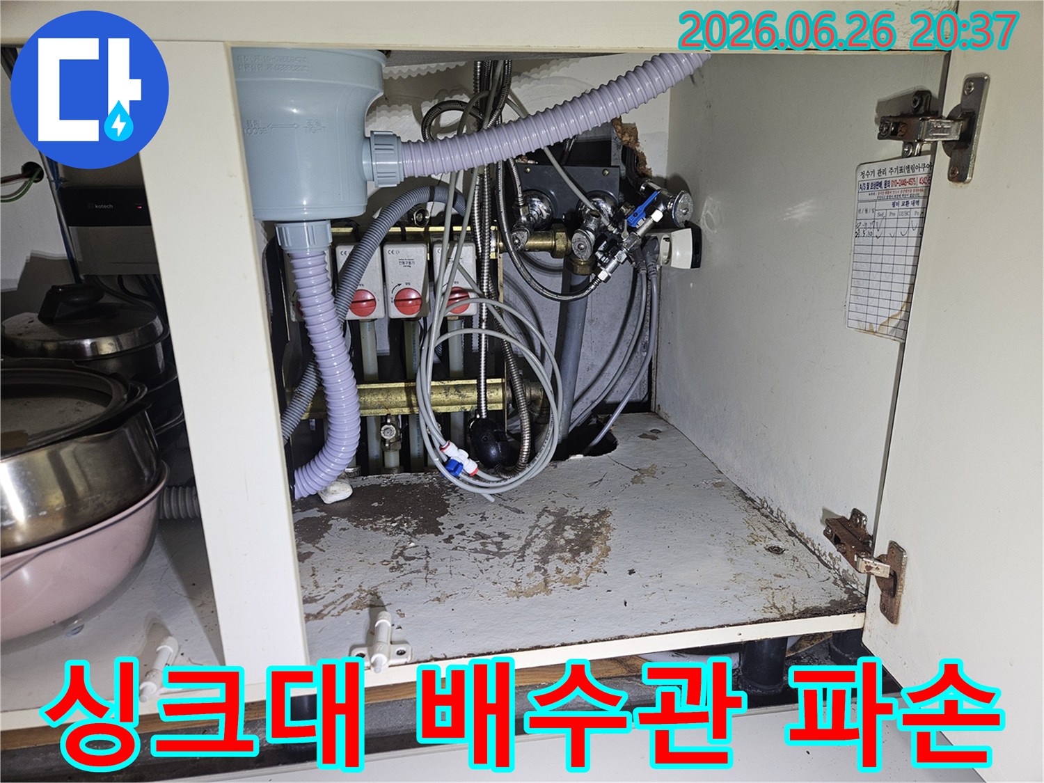 싱크대 하부 캐비닛 안-오래된 배수관 연결 부위에서 물이 새어-바닥에 얼룩을 만든 모습