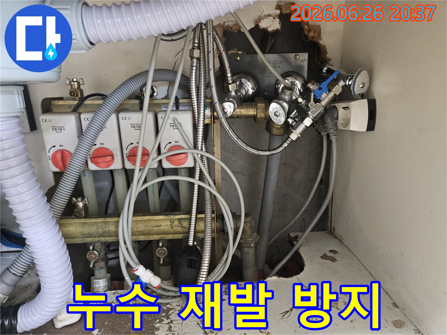 이 이미지는-누수 재발 방지 공사 전-보일러실의-복잡한 배관과-전기 연결부-그리고-벽면의 손상된-부분을-보여줍니다