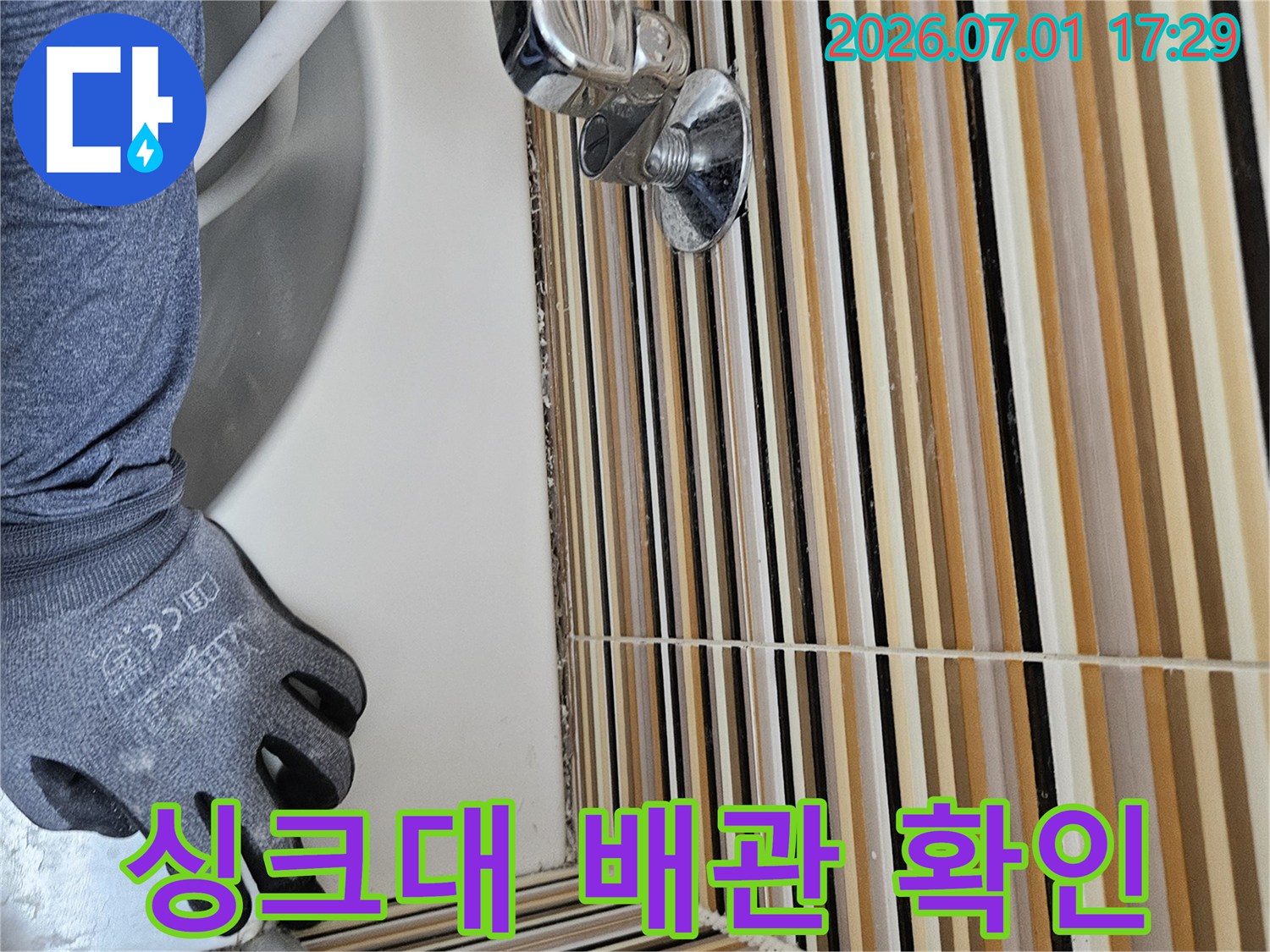 누수 전문 기술자가-싱크대 하부 배관의-연결 상태와 노후 여부를-세심하게 확인하는 모습