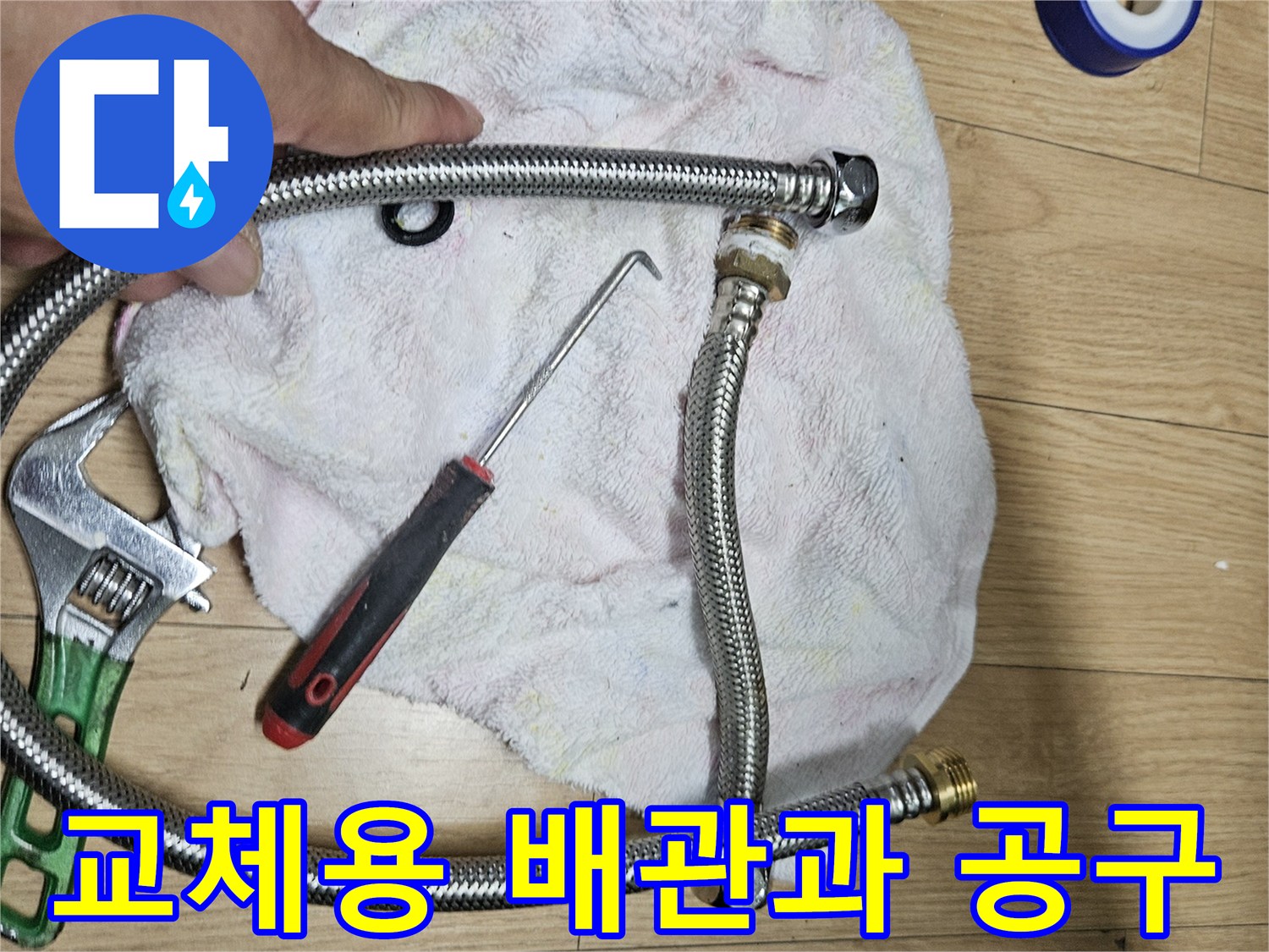 새 주름관 부품과 파란색 테이프 및 수리 도구들