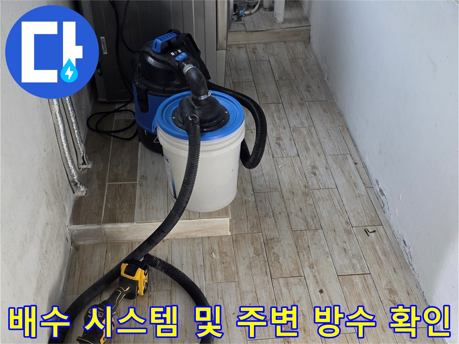 세탁실 배수구 부근에 장비를 연결하여 누수 여부를 정밀 진단하는 모습