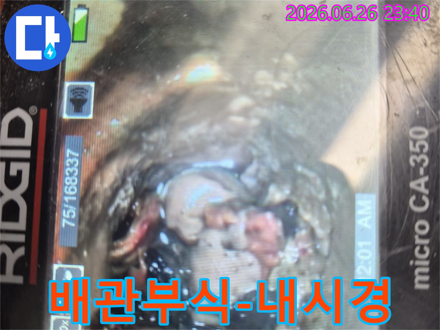 배관 내시경 카메라로-하수관 내부를 촬영하여-이물질과 함께-심각하게 부식된-배관 벽면의 상태를-보여주는 이미지입니다.