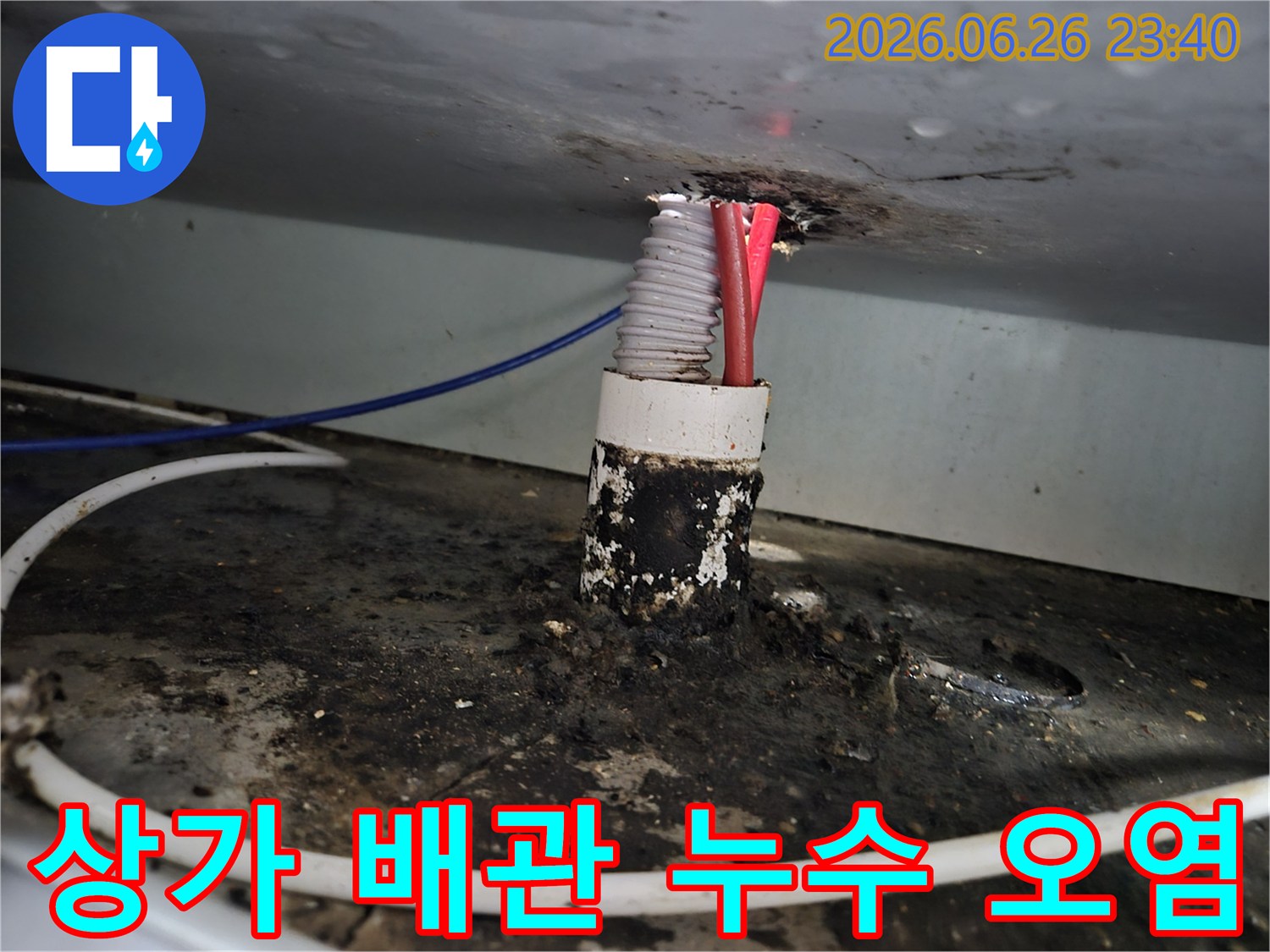 상가 건물 내부의 배관 틈새에서 발생한 누수로 인해-주변이 심하게 오염된 모습을 보여줍니다.