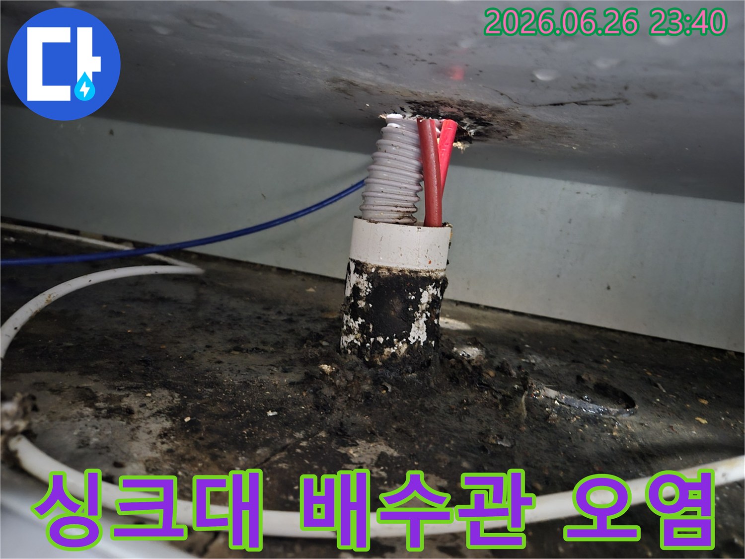아파트 싱크대 배수관 틈새에서 발생한 누수로 인해-주변이 심하게 오염된 모습을 보여줍니다.