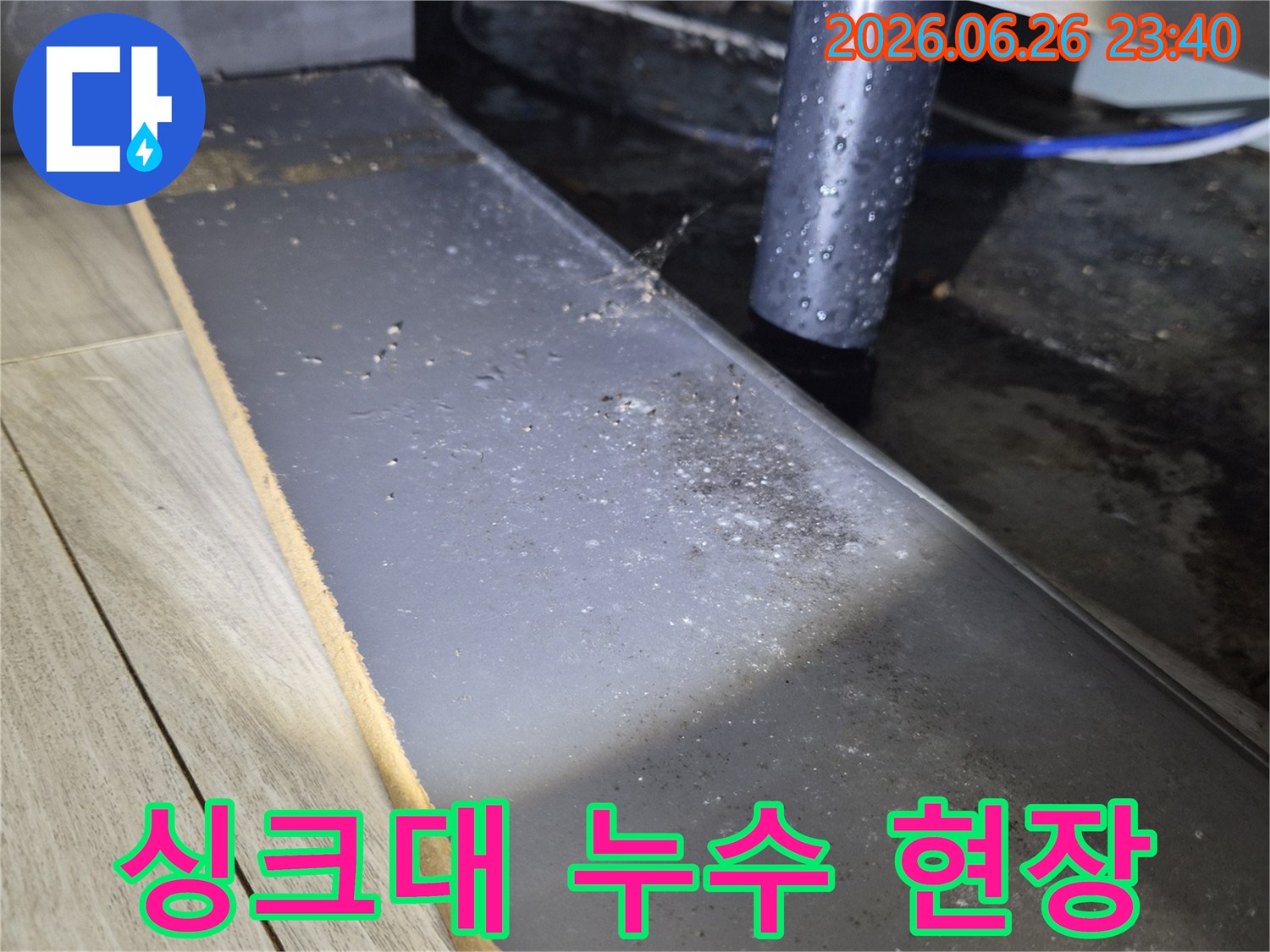 주방 싱크대 하부의 배수관에서 물이 새어-주변에 물기가 맺힌 모습을 보여주는 사진
