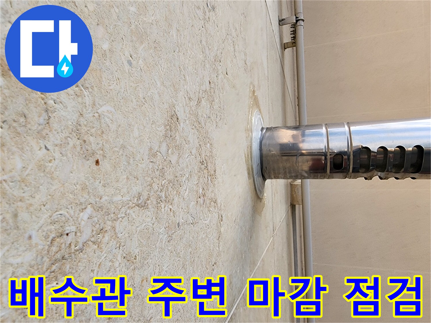 석재 벽면의 스테인리스 배수관 연결 지점 근접 촬영