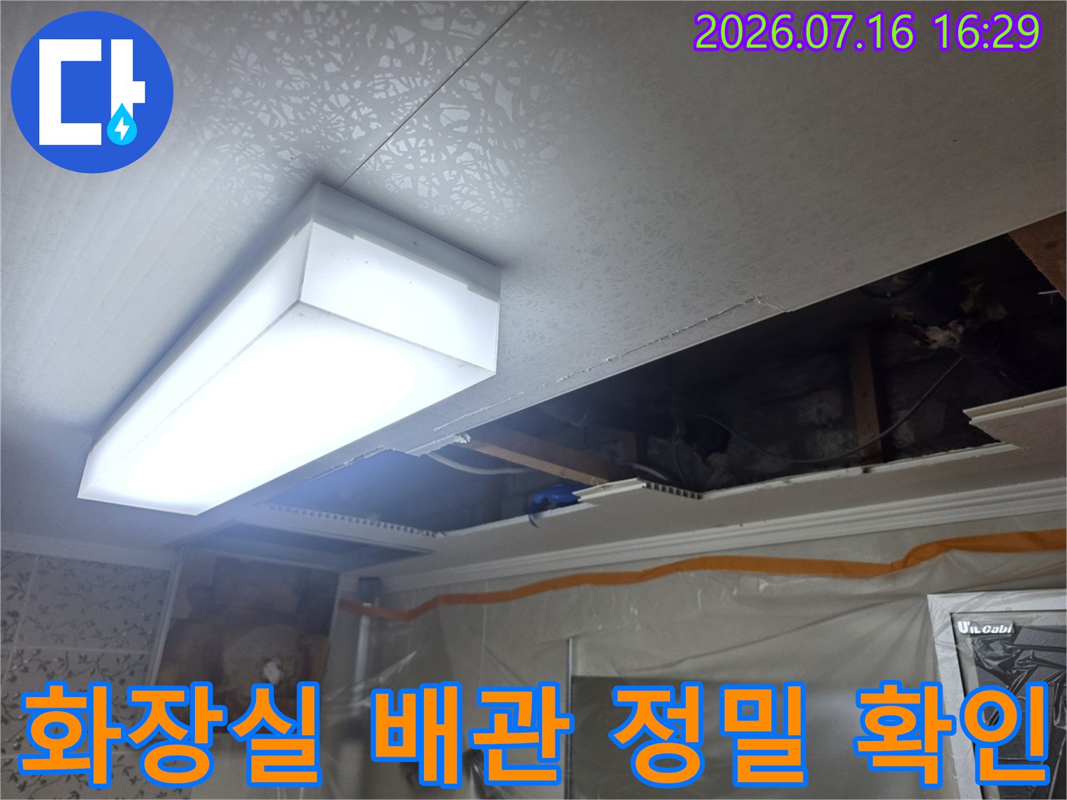 천장 내부에 노출된 화장실 배관 및 조명부 점검 장면