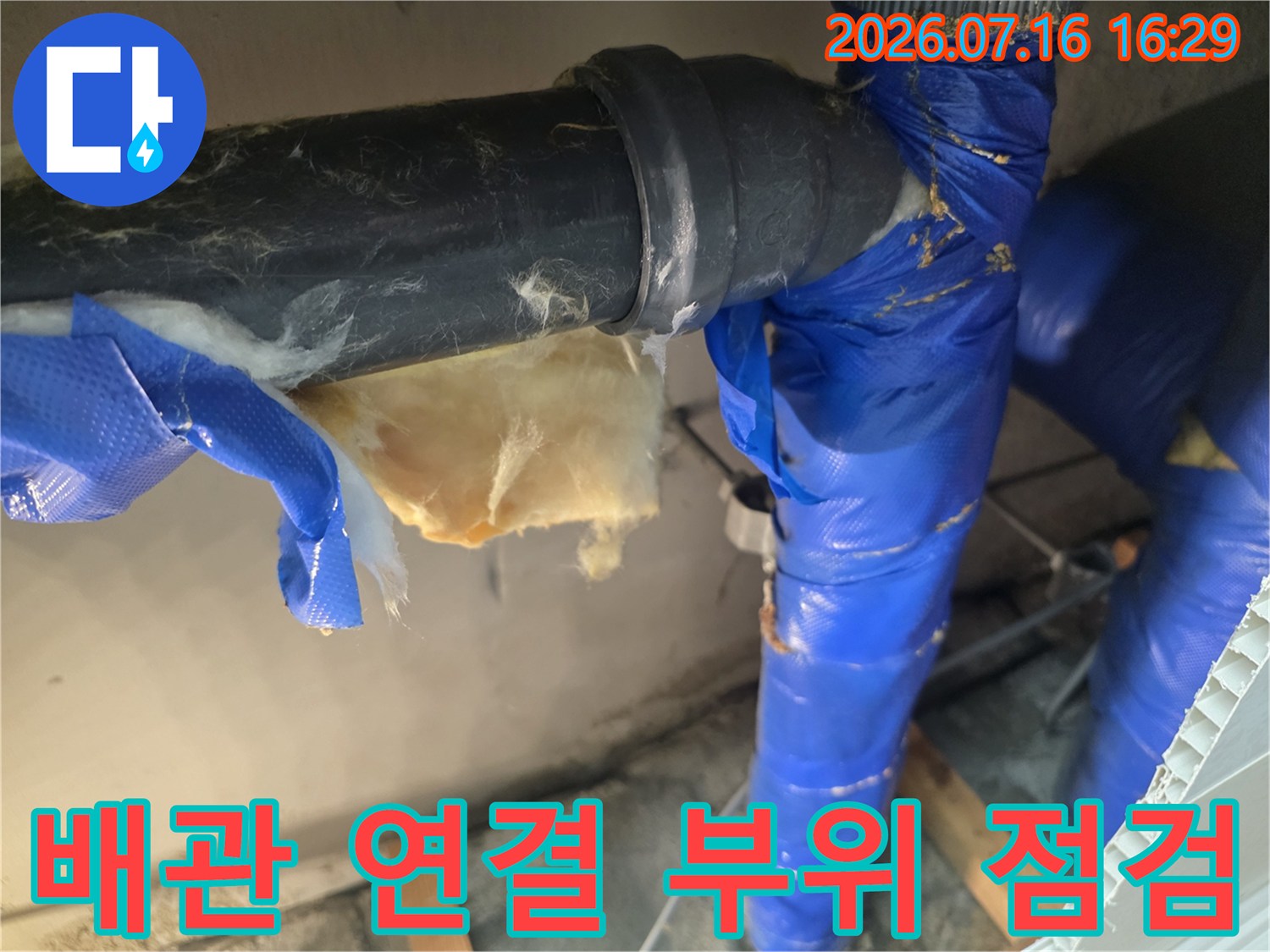 파란색 보온재로 감싸진 배관의 연결 부위를 점검하는 모습