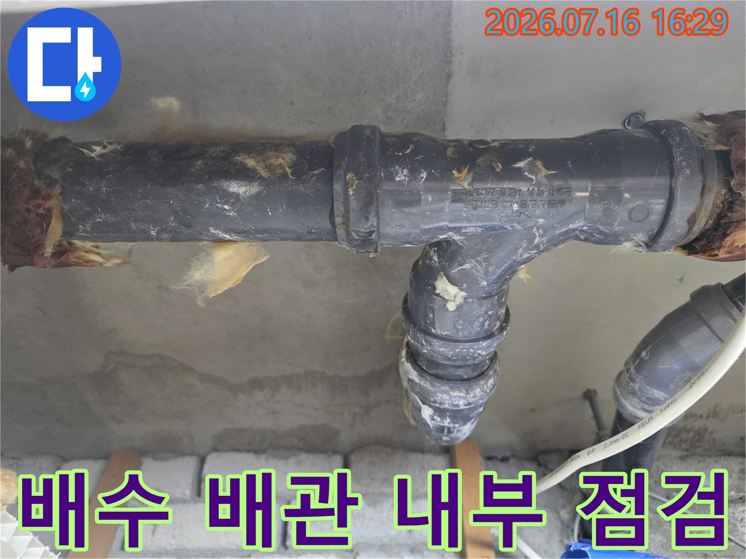 화장실 천장 내부에 위치한 배수 및 오수 배관의 상태를 확인하는 모습
