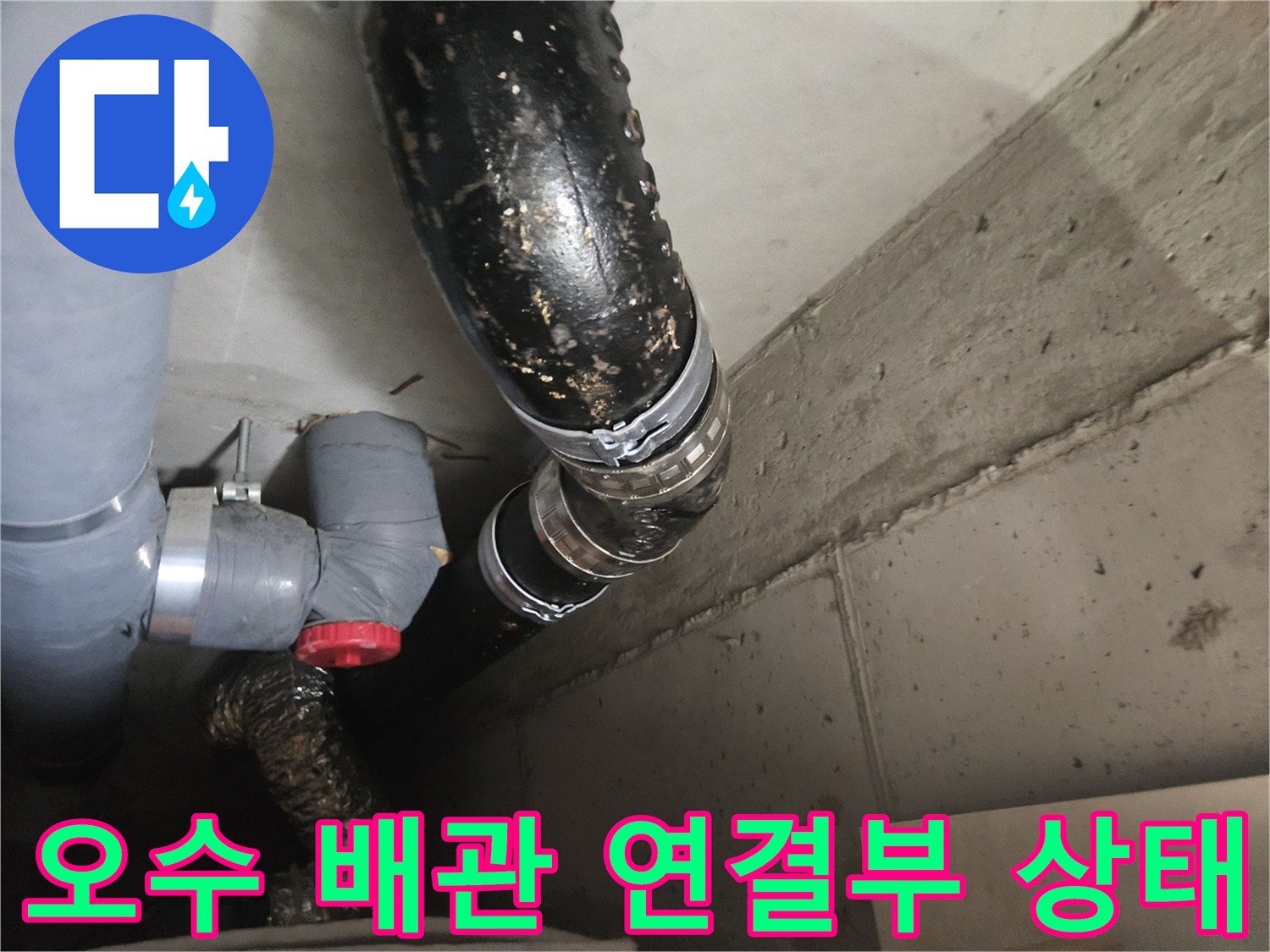 습기가 스며든 검은색 오수관과 회색 PVC 배관의 결합 부위