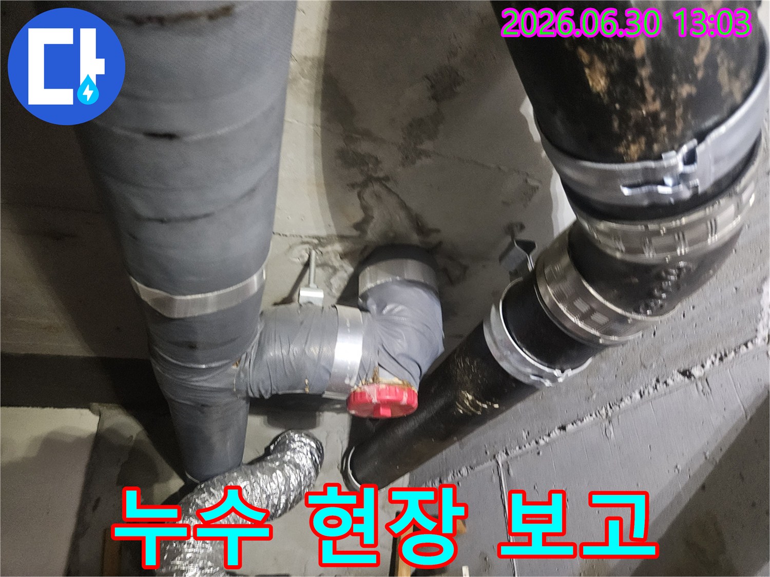 아파트 지하 배관에서 물이 새어-콘크리트 벽면이 젖어있는 상태로-누수 현장 보고를 준비 중입니다.