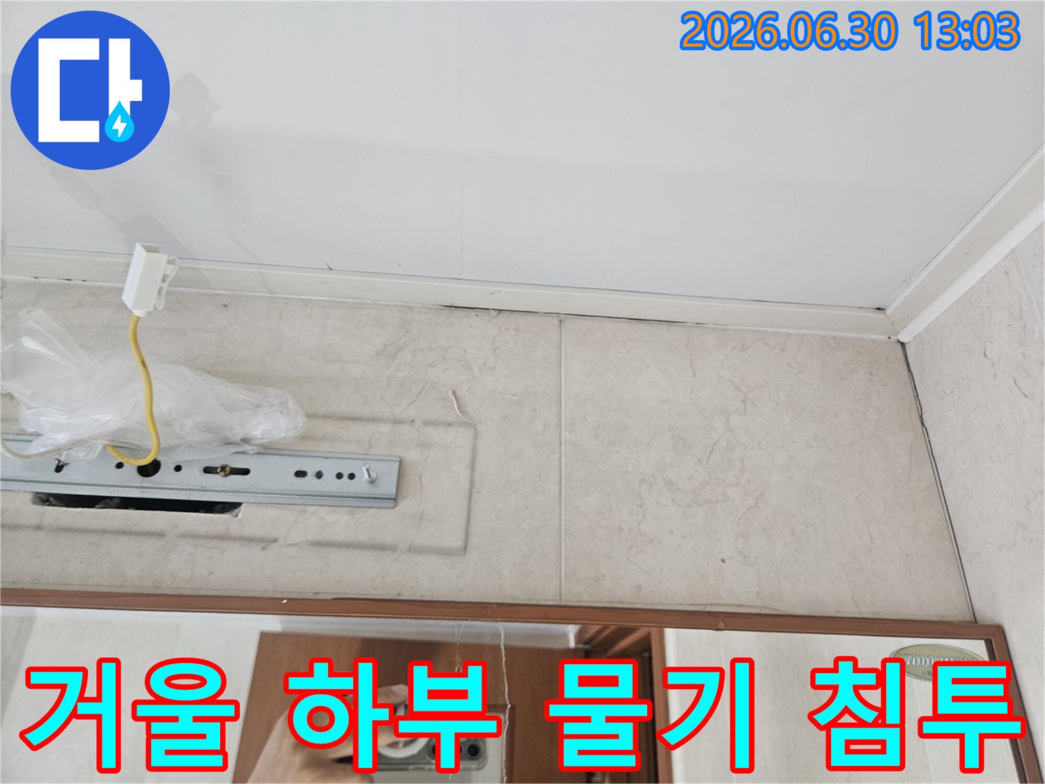 욕실-거울-하단부와-타일-경계에-물기가-침투한-현장을-보여주는-사진