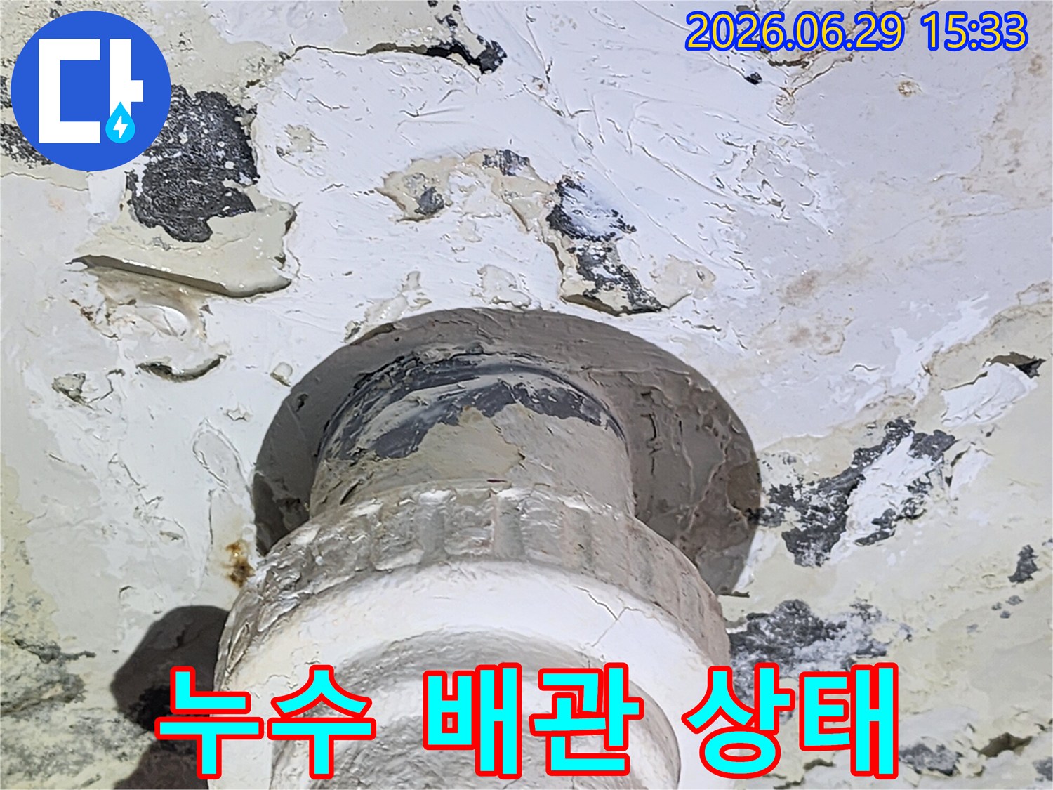 물샘으로 인해-천장 마감이 손상된-배관 연결 부위의-클로즈업 사진입니다.