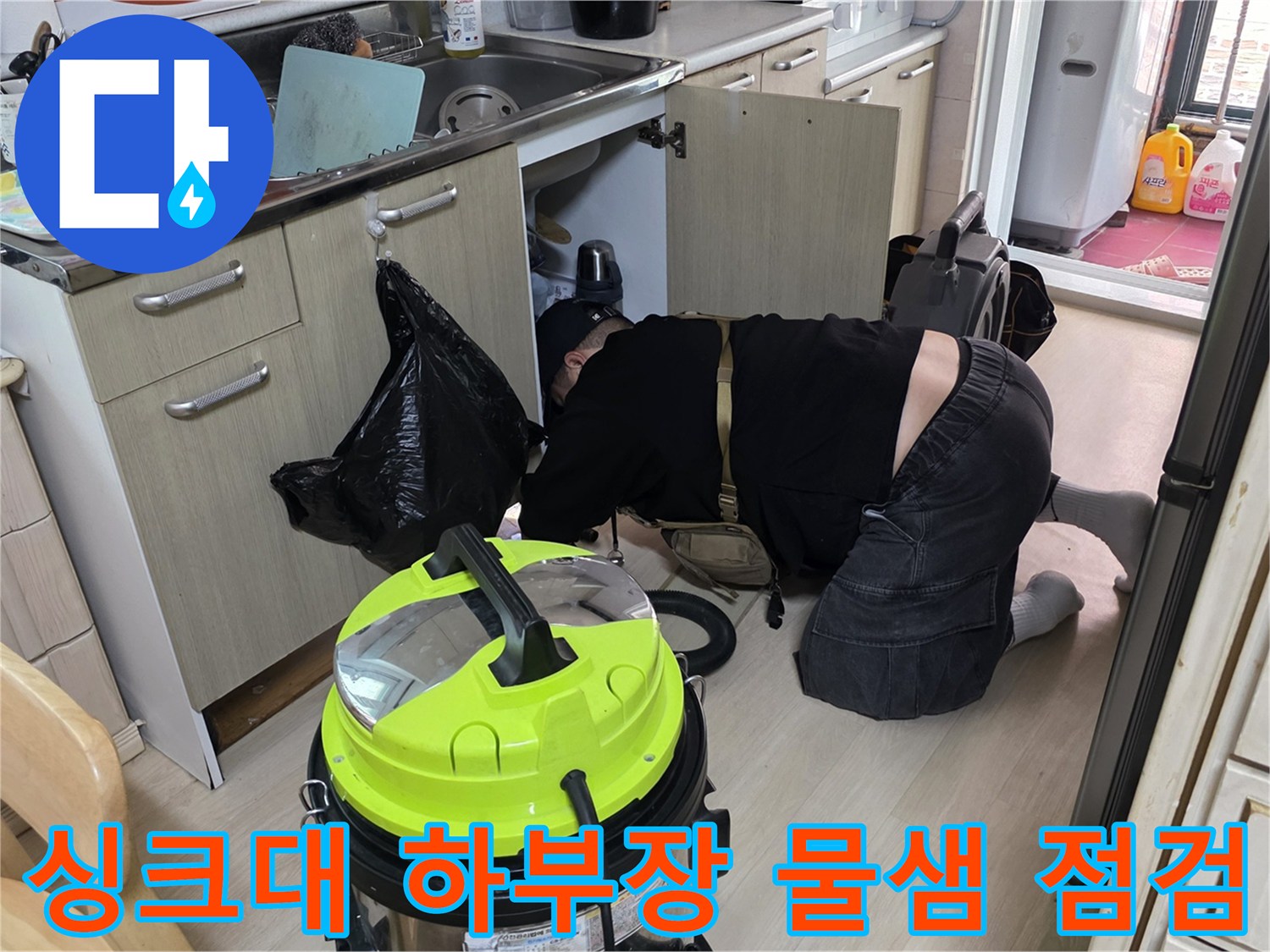 싱크대 배수 호스 주변의 잔수를 집진기로 제거하는 작업 현장