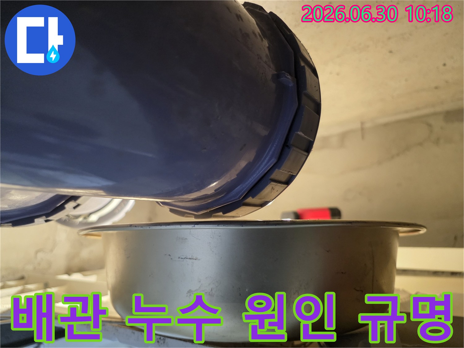 누수-현장에서-배관에서-물이-새는-것을-발견하고-아래에-물받이를-놓아-누수-원인을-규명하고-대책을-마련하고-있는-사진입니다.