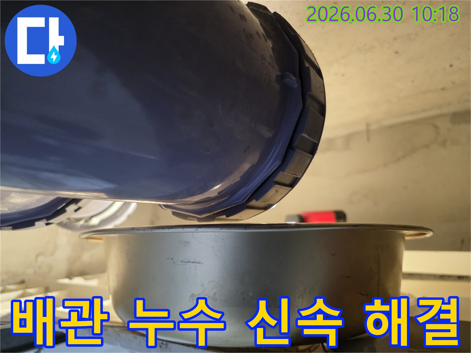 누수-현장에서-배관에서-물이-새는-것을-발견하고-아래에-물받이를-놓아-신속하게-대응하고-있는-모습을-담은-사진입니다.