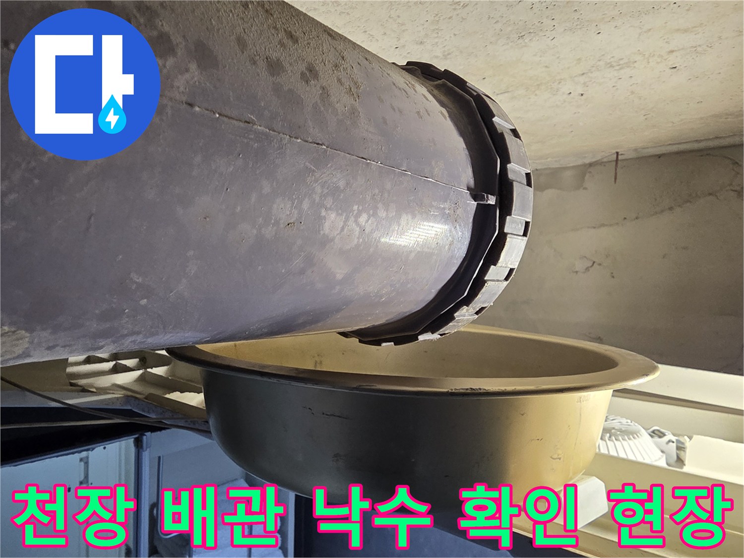 배관 연결부와 물받이 - 배관에서 떨어지는 물을 받기 위해 설치된 금속 용기입니다.
