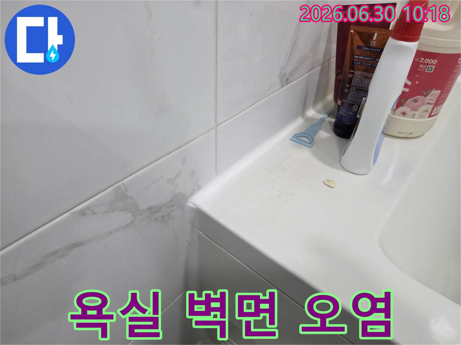 욕실 세면대 옆 벽면 타일에-물 스밈으로 인한 오염이 발생한-누수 현장 사진입니다