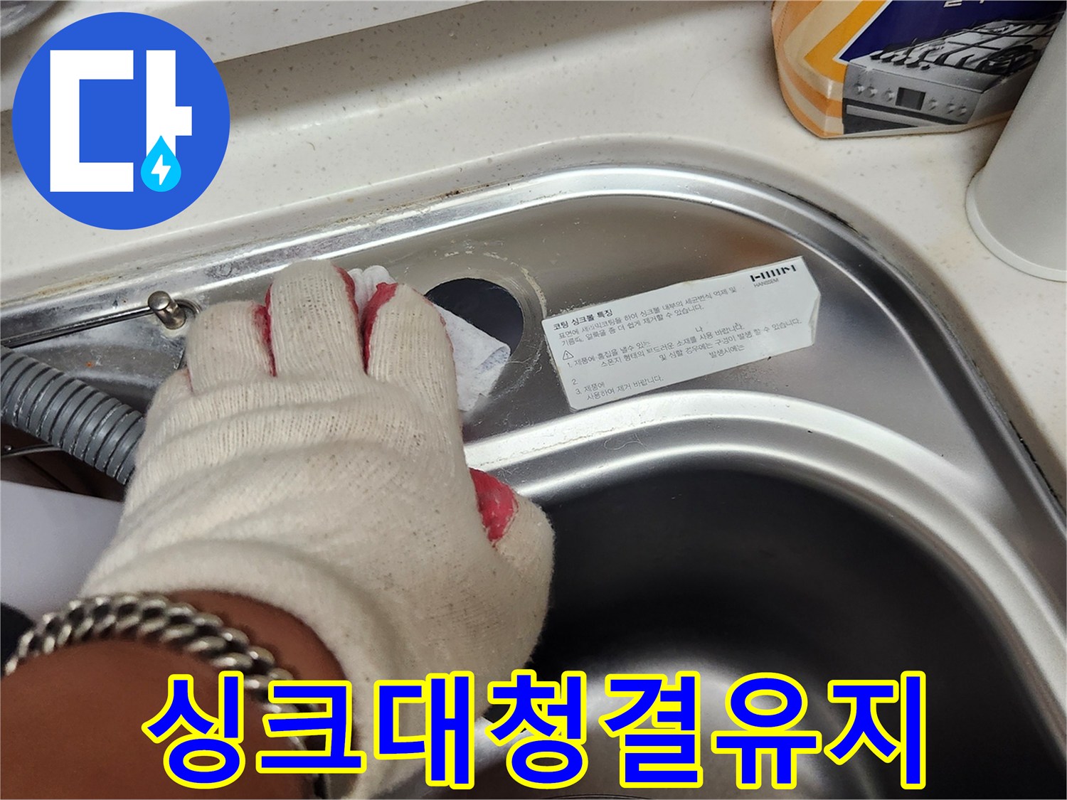 수도꼭지 교체 전-싱크대 주변을 깨끗하게 청소하는 작업 모습.