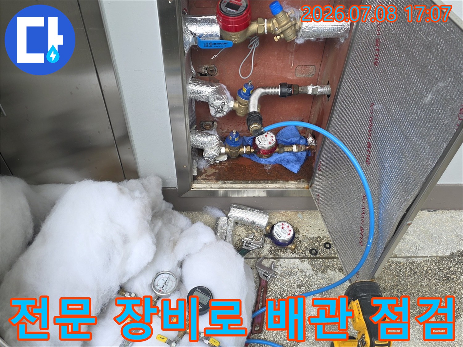 파란색 호스와 게이지를 연결하여 화장실 내 노출 배관을 정밀 점검함