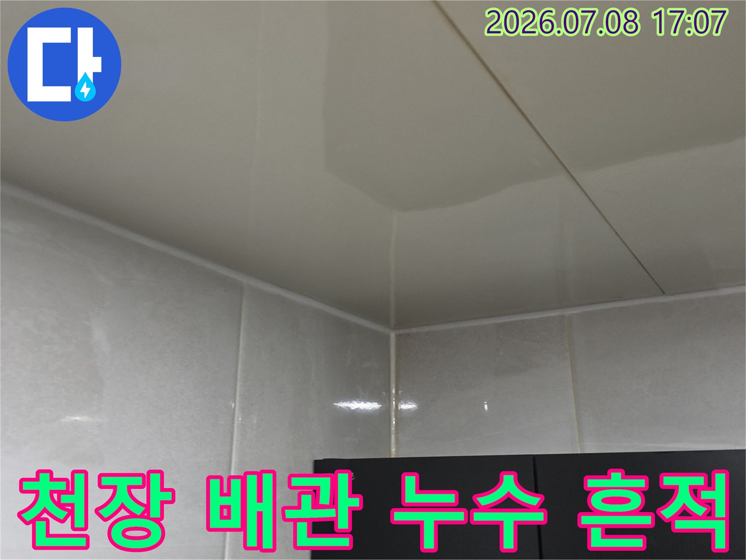 화장실 천장 내부의 흰색 타일 마감과 배관 연결부 점검 장면
