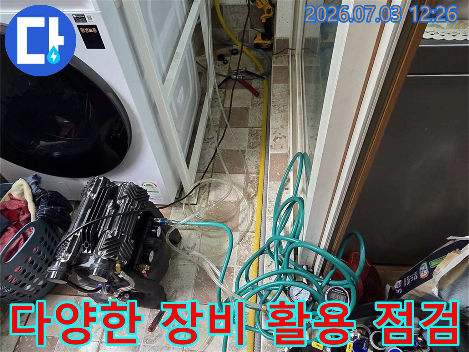세탁기 구역 내 배관망에 멀티 게이지와 호스를 연결하여 정밀 검사 중인 장면