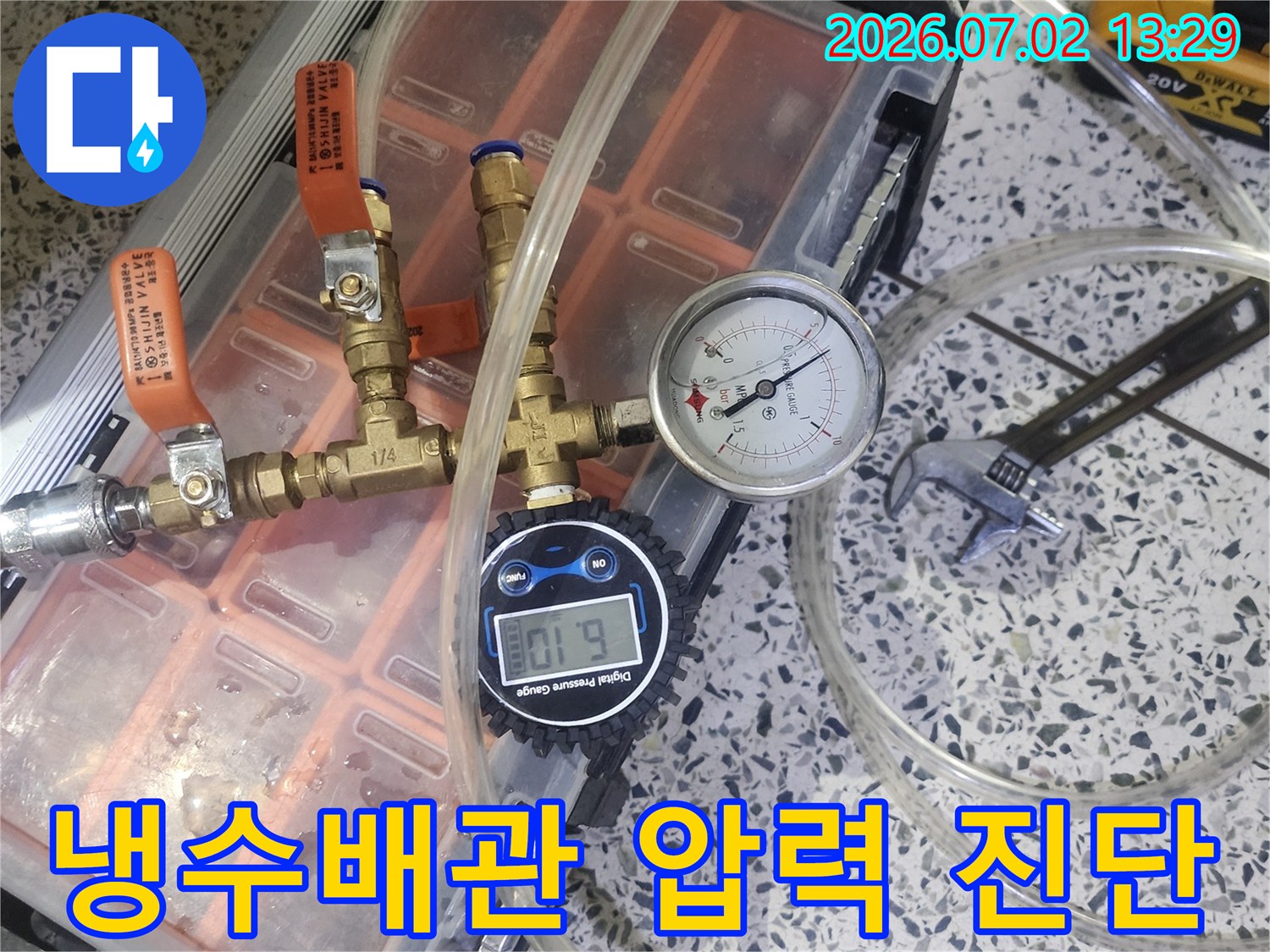 냉수배관의 누수 여부를 확인하기 위해 압력 게이지가 연결된 전문 테스트 장비를 사용하고 있습니다
