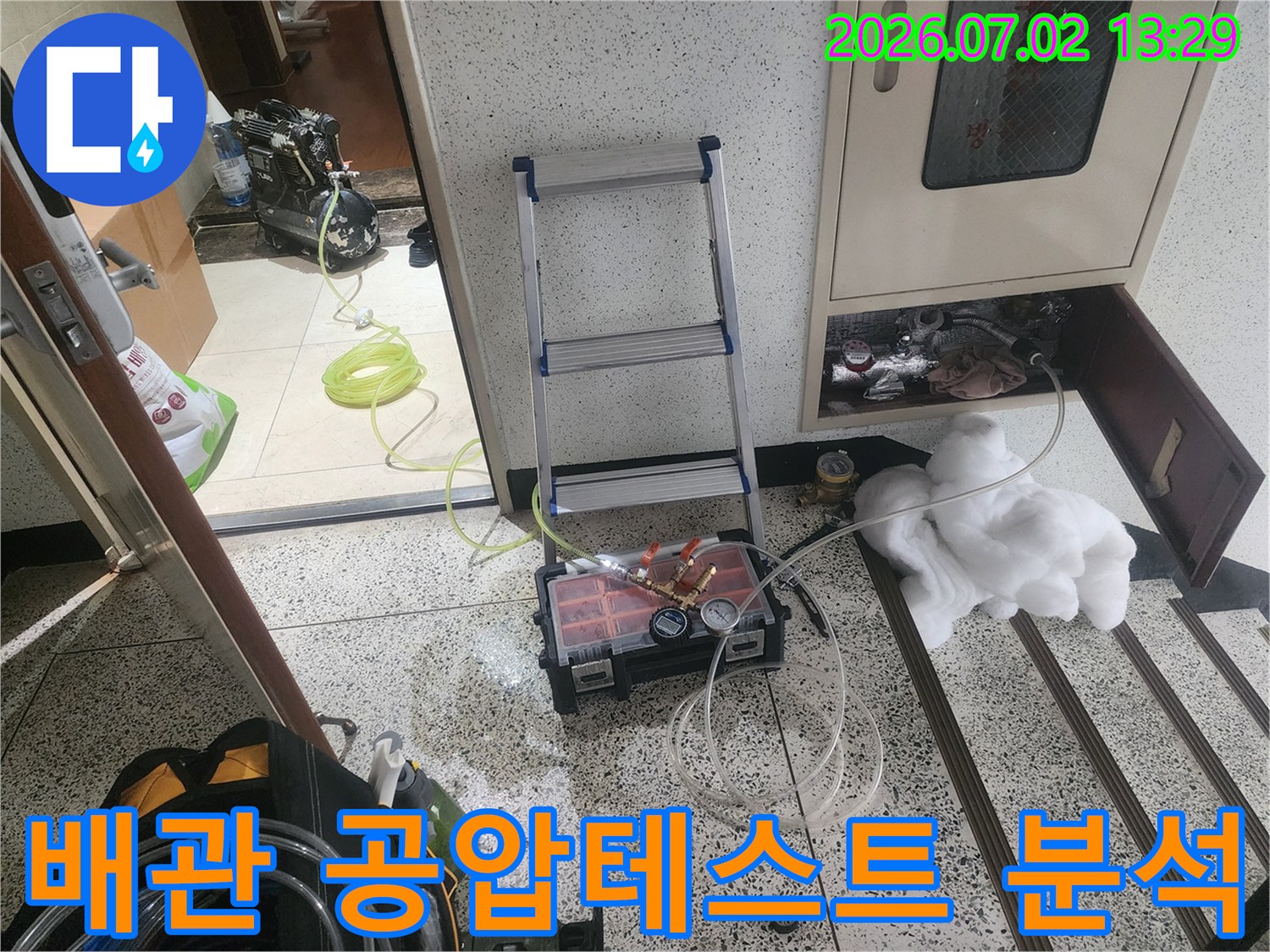 울산 우정동에서 배관 누수 지점을 정밀하게 분석하기 위해-직수 및 온수 배관에 공압테스트 장비를 연결하고-압력 변화를 면밀히 관찰하는 전문 작업 현장입니다.