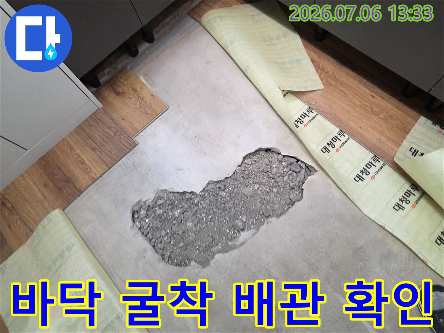 누수 지점을 찾기 위해 바닥을 파내어 노출된 콘크리트와 배관 부위를 점검하는 모습