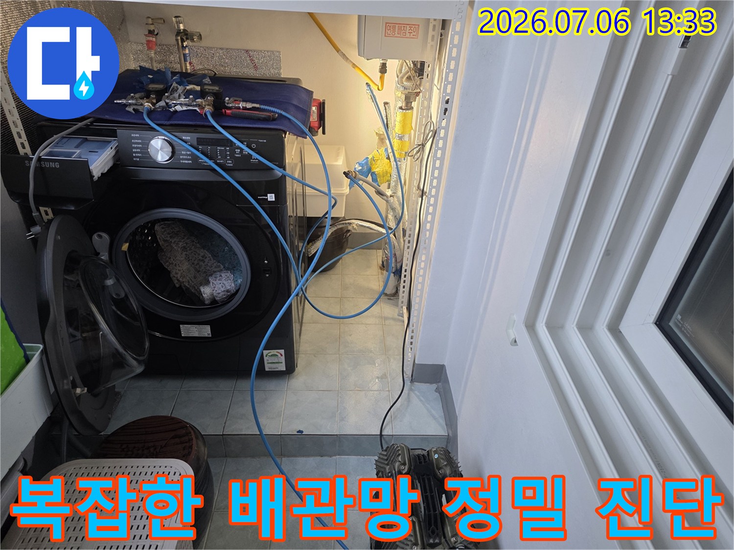 세탁 공간 옆에 위치한 복합적인 수도 배관 시스템을 점검하는 모습