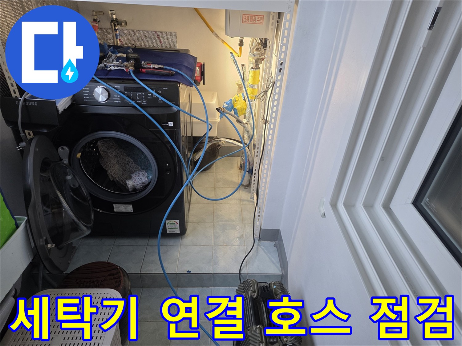 세탁기 주변-파란색 점검 호스와 수도 부속품들