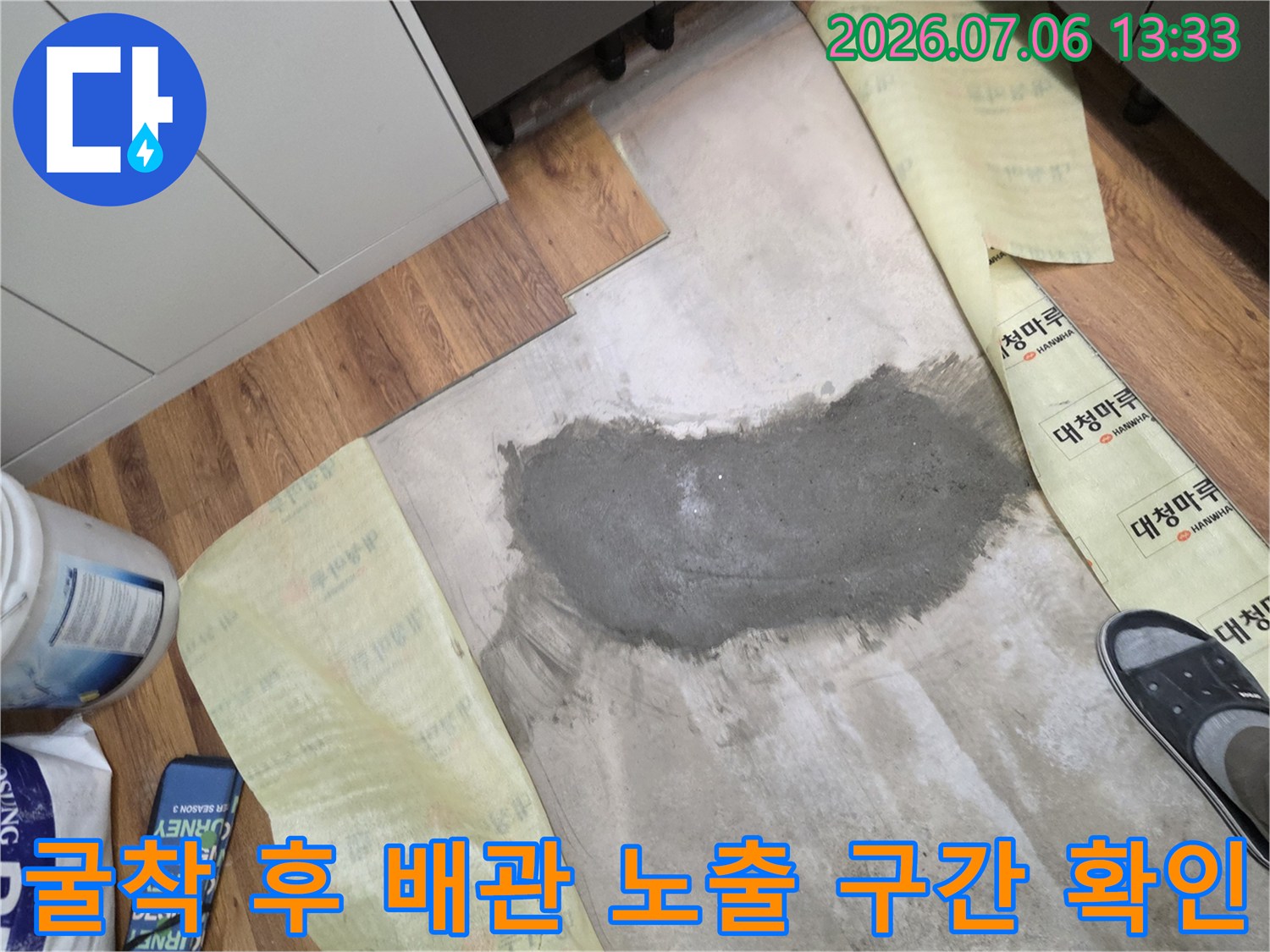 파헤쳐진 바닥 아래의 젖은 콘크리트와 배관 파손 부위