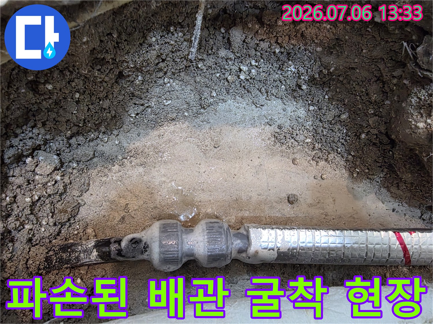 흙 속에 노출된 보온재를 입은 배관과 연결 부위의 누수 확인 장면