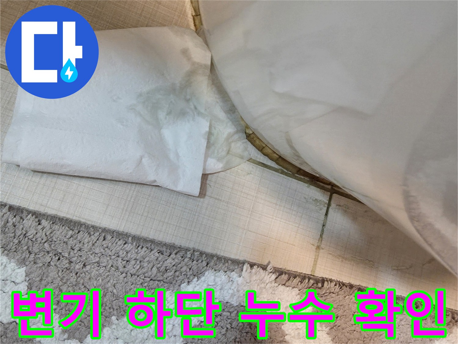 변기 밑 타일 틈새의 물기를 휴지로 짚어보며 상태를 점검하는 사진