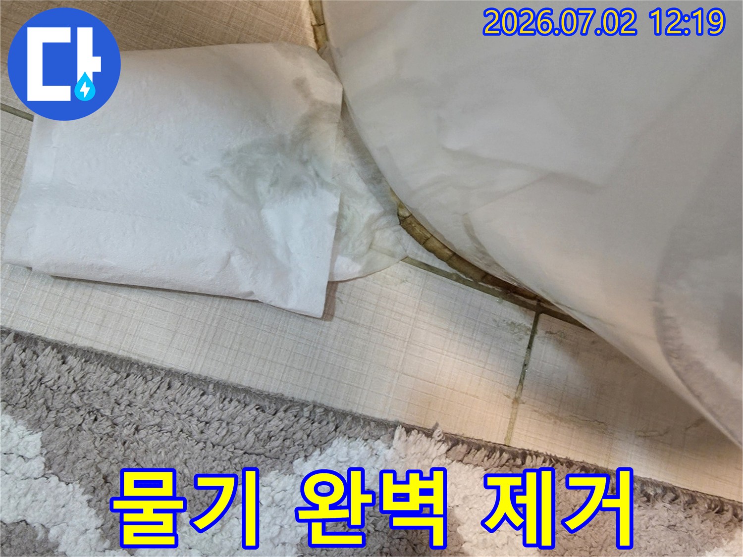 변기 하부에서-물이 새어-나와-바닥에-물기가-고여있는-누수-현장을-보여주는-사진입니다.